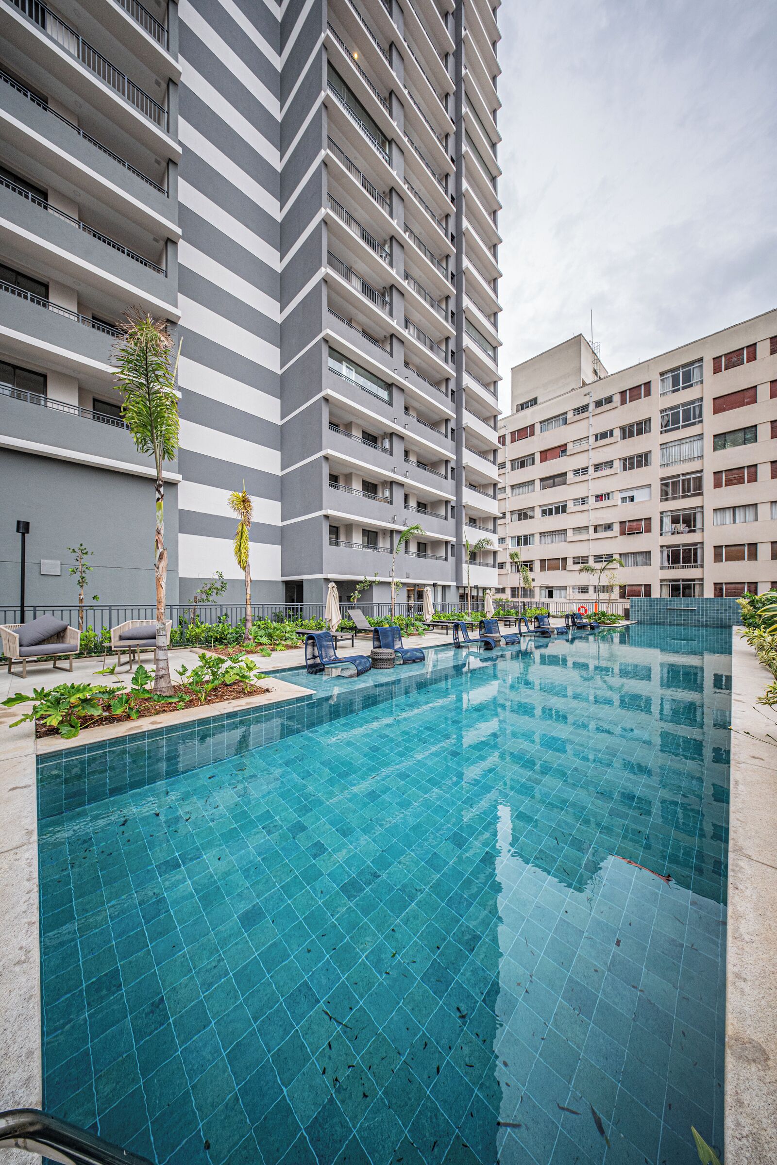 Un hôtel moderne doté d’une grande piscine extérieure, de nombreux balcons et d’espaces de détente en plein air.