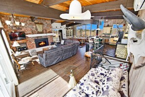 Ein gemütliches Wohnzimmer mit Kamin, Ledersofa und rustikalem Dekor.