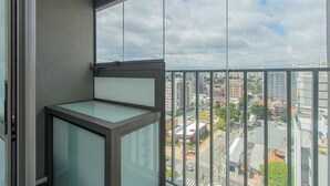 En balkon med udsigt over bybilledet, inklusive bygninger og en gade.