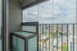 Ein Balkon mit Blick auf eine Stadtansicht, einschließlich Gebäude und einer Straße.