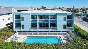 A two-story building with a swimming pool in front. - Beachfront Condo w/ Pool & Gulf Views I Anna Maria Island I Seaside Beach Villa |   Steps to the Beach (Holmes Beach)