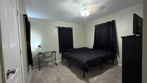 A bedroom with a bed, a desk, a chair, a ceiling fan, and a television. - Affordable private room King bed in Thonotosassa, shared space (Thonotosassa)