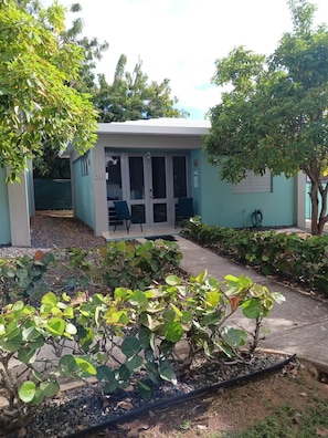 A building with a covered outdoor seating area, numbered 26, surrounded by greenery and trees. - Private Villa Minutes from the Beach in Beautiful Boquerón — Cool A/C Included (Boquerón)