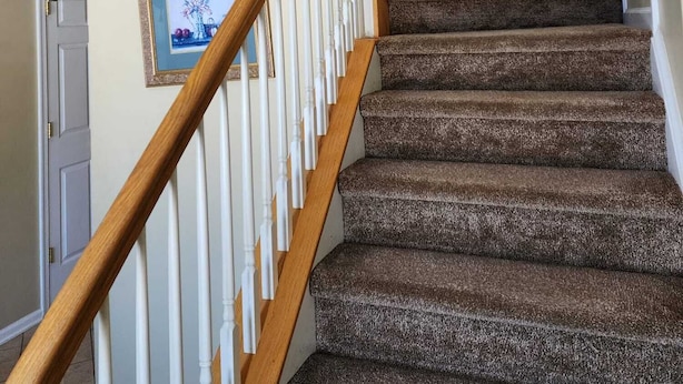 Eine Treppe mit Holzbalkonen und beigen Wänden.