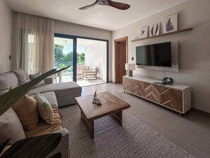 Ein modernes Wohnzimmer mit einer Couch, einem Couchtisch und einem Fernseher.