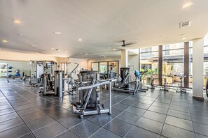 A gym with various exercise machines, large windows, and a tiled floor. - Peaceful cozy retreat (Addison)