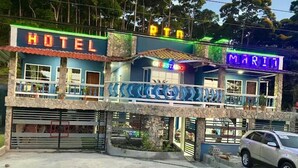 A hotel with a sign reading "HOTEL" and another sign for "MARIT." - Hotel Rio Maria (La Ceiba)