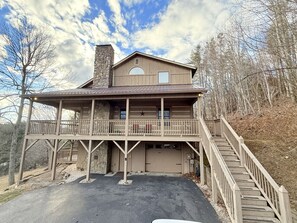 Une maison à deux étages dotée d’un balcon, d’un garage et d’un escalier menant à l’étage supérieur.