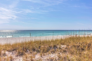 A beach with clear turquoise water and a sandy shore. - Beachside Gem ~ Remodeled Luxury Steps to Sand (Miramar Beach)