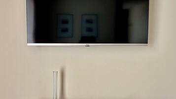 Un televisor de pantalla plana montado en la pared sobre una repisa de madera.