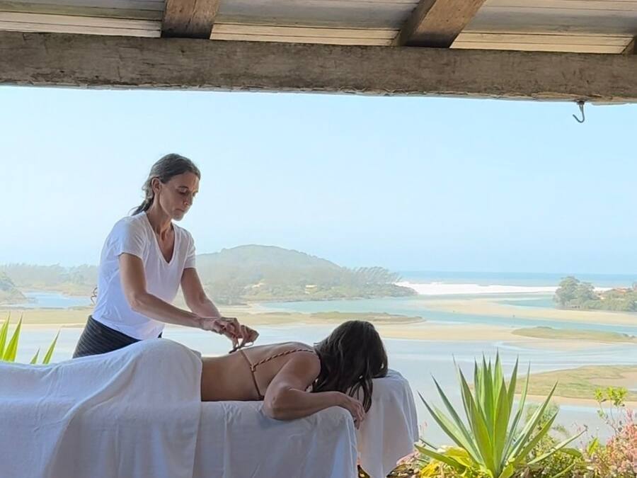 Een massage therapie sessie in een ruimte met uitzicht op een kustlandschap.