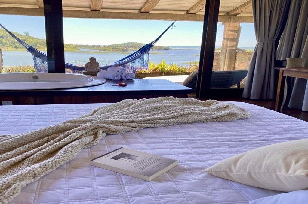 Un dormitorio con vista a un lago, una hamaca y una estatua sobre una mesa.