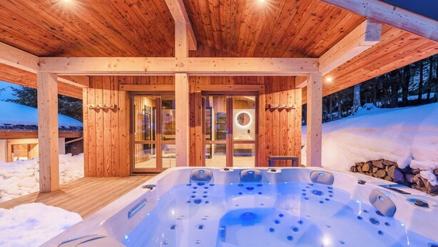 A wooden cabin with a hot tub and a glass door entrance. - Luxury Chalet with Private Spa & Wellness Area (Megève)