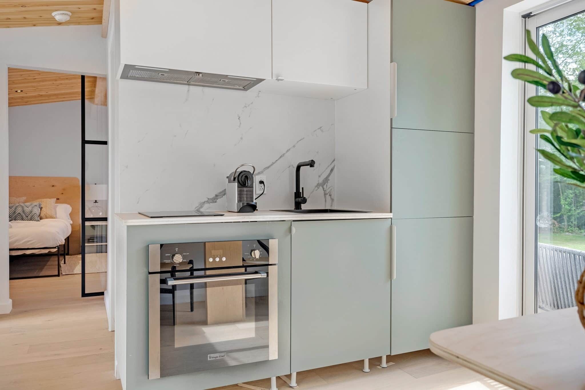 A modern kitchen with a built-in oven, a sink, and a stove.