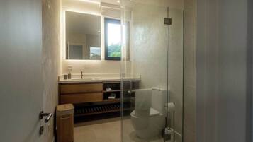 A modern bathroom with a glass shower enclosure, a large mirror, and a wooden vanity.