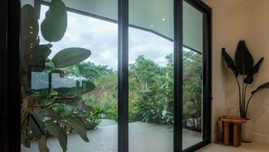 A modern interior with large glass doors leading to a garden. - Hillside Oceanview Home with Pool in Venao (Playa Venao)