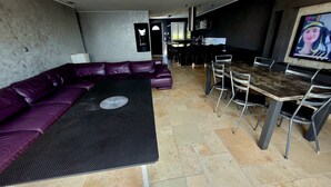 A modern living area with a sectional sofa, a dining table with chairs, and a television. - Les Oliviers du Pouget -Superb villa with heated pool & air conditioning (Le Pouget)