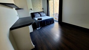 A bedroom with a bed, a small table, and a large window with curtains. - Les Oliviers du Pouget -Superb villa with heated pool & air conditioning (Le Pouget)
