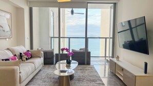 A modern living room with a sofa, coffee table, and a TV. - Amazing experience with ocean views on Balboa Ave (Panamá)