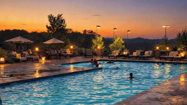 A swimming pool with lounge chairs and umbrellas, surrounded by trees and a fence. - 4 Ensuites, Championship Golf, Pool, Hottub, 30ft Patio with Outdoor Dining. (Branson)