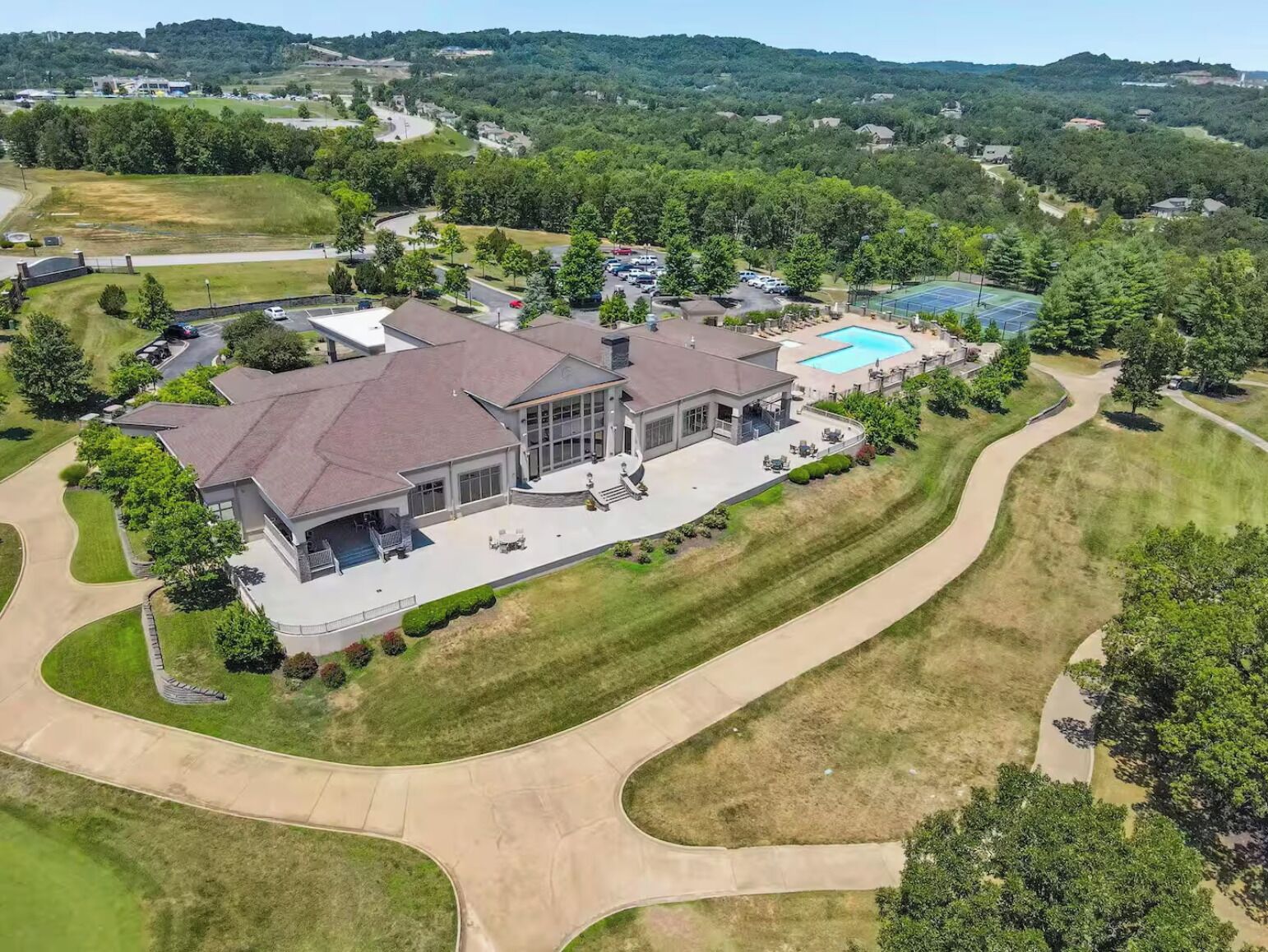 Une grande maison moderne dotée d’un vaste patio et d’une piscine.