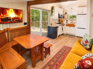 Un salon chaleureux avec une table à manger en bois, un canapé et une cheminée.