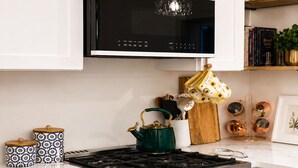 A kitchen with a stove, a microwave, and various kitchen utensils. - Riverside Cottage • Private Beach • Mountain Views (Bartlett)