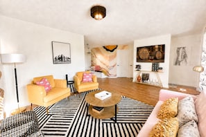 Un salon moderne avec un canapé, des fauteuils, une table basse et un tapis.