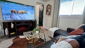 A living room with a TV, sofa, coffee table, and decorative items.