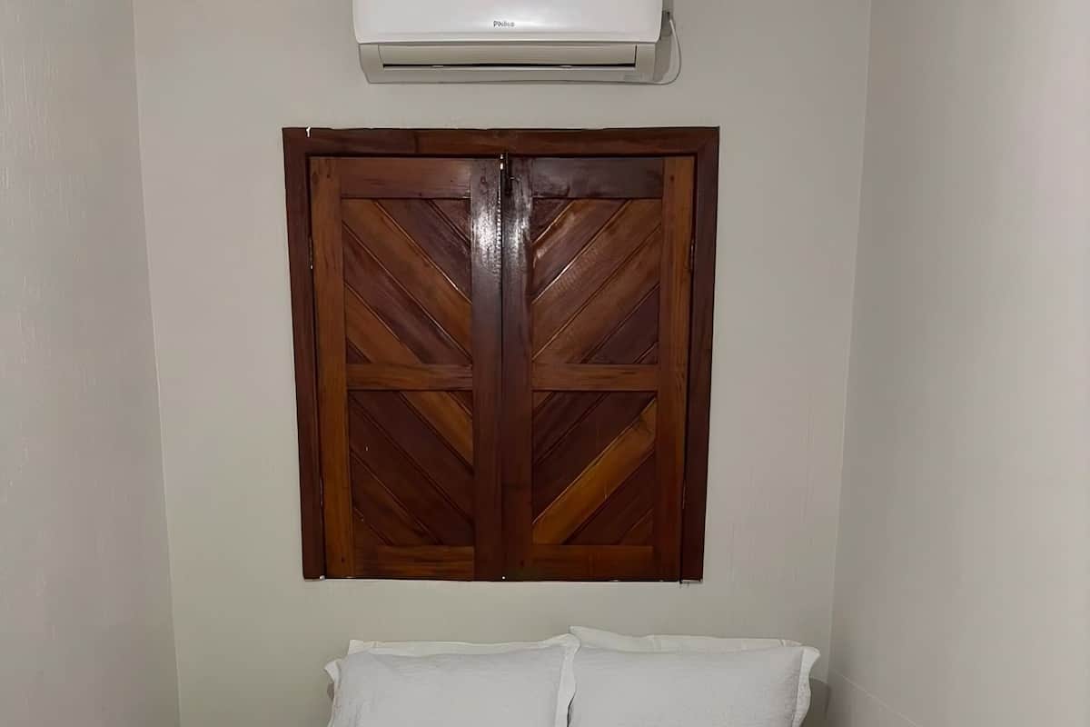 Una cama impecablemente hecha con sábanas blancas y una decoración de toallas en forma de corazón.
