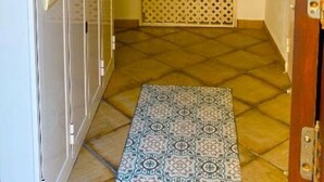 Een hal met een kamerbreed tapijt, een decoratieve poort en een plafond met houten balken.