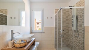 A modern bathroom with a large sink, a glass shower enclosure, and a window providing natural light. - Room Maria Lai(I Centenari Longevity Rooms) Property located 1 km from the beach (Lotzorai)