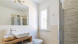 A modern bathroom with a large mirror, a freestanding sink, a bidet, and a glass shower enclosure. - Room Maria Lai(I Centenari Longevity Rooms) Property located 1 km from the beach (Lotzorai)