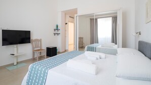 A hotel room with a large bed, a TV, a chair, and a small table. - Room Maria Lai(I Centenari Longevity Rooms) Property located 1 km from the beach (Lotzorai)