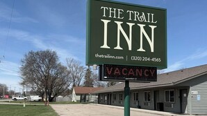 A sign for 'The Trail Inn' with a digital display indicating 'VACANCY'.