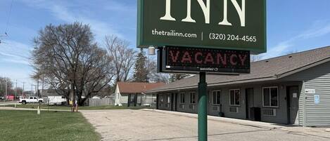 A sign for 'The Trail Inn' with a digital display indicating 'VACANCY'.