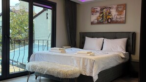 A modern bedroom with a large bed, a view of the outside, and a ceiling light. - Ortaköy Suit (İstanbul)
