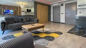 A modern living room with a grey sofa, a wooden coffee table, and a patterned rug. - Ortaköy Suit (İstanbul)