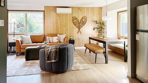 Un soggiorno moderno con una parete in legno, un divano, un tavolino e una panca.