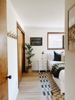 Une chambre à coucher avec un lit, une table de chevet, une lampe et un tableau au mur.