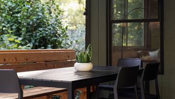 A shaded porch table, framed by forest — perfect for a quiet breakfast.
