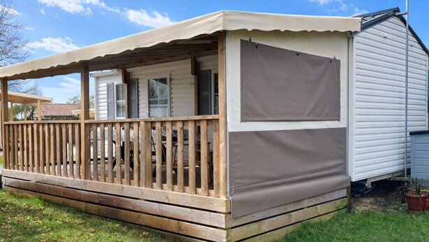 A mobile home with a wooden deck, a covered porch, and a satellite dish. - Fully equipped mobile home for 4–6 people in Hourtin, between the lake, the forest, and the ocean🏖️ (Hourtin)