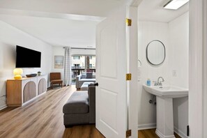 Un salon moderne avec un téléviseur à écran plat, un meuble en bois et un canapé.