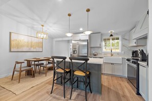 A modern kitchen with a central island, stainless steel appliances, and pendant lighting. - Private 4BR/3BA  Home Near IAH• Sleeps 9•Fast WIFI•Work Stays & Groups (Houston)