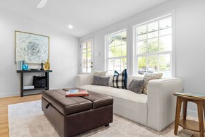 A modern living room with a large window, a sofa, a coffee table, and a side table. - Private 4BR/3BA  Home Near IAH• Sleeps 9•Fast WIFI•Work Stays & Groups (Houston)