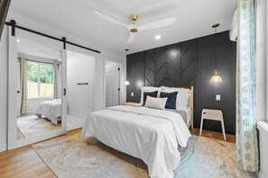 A modern bedroom with a bed, a ceiling fan, and a small stool. - Private 4BR/3BA  Home Near IAH• Sleeps 9•Fast WIFI•Work Stays & Groups (Houston)