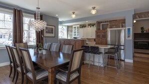 A modern kitchen with wooden cabinets, a dining area with a large table and chairs, and a bar area with stools. - Your Perfect CU Graduation Headquarters: Walk to Folsom & Pearl St!
New Listing! (Boulder)