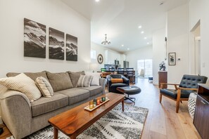 Un salon moderne avec un canapé, une table basse et des œuvres d’art accrochées au mur.