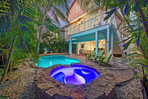 A house with a swimming pool and hot tub, surrounded by tropical plants. - NEW! Steps to Private Beach, Heated Pool, Hot Tub, + Ping Pong (Holmes Beach)