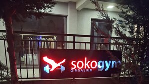 Schild mit einem Känguru und einem Kreuzsymbol, das ein Fitnesscenter kennzeichnet.